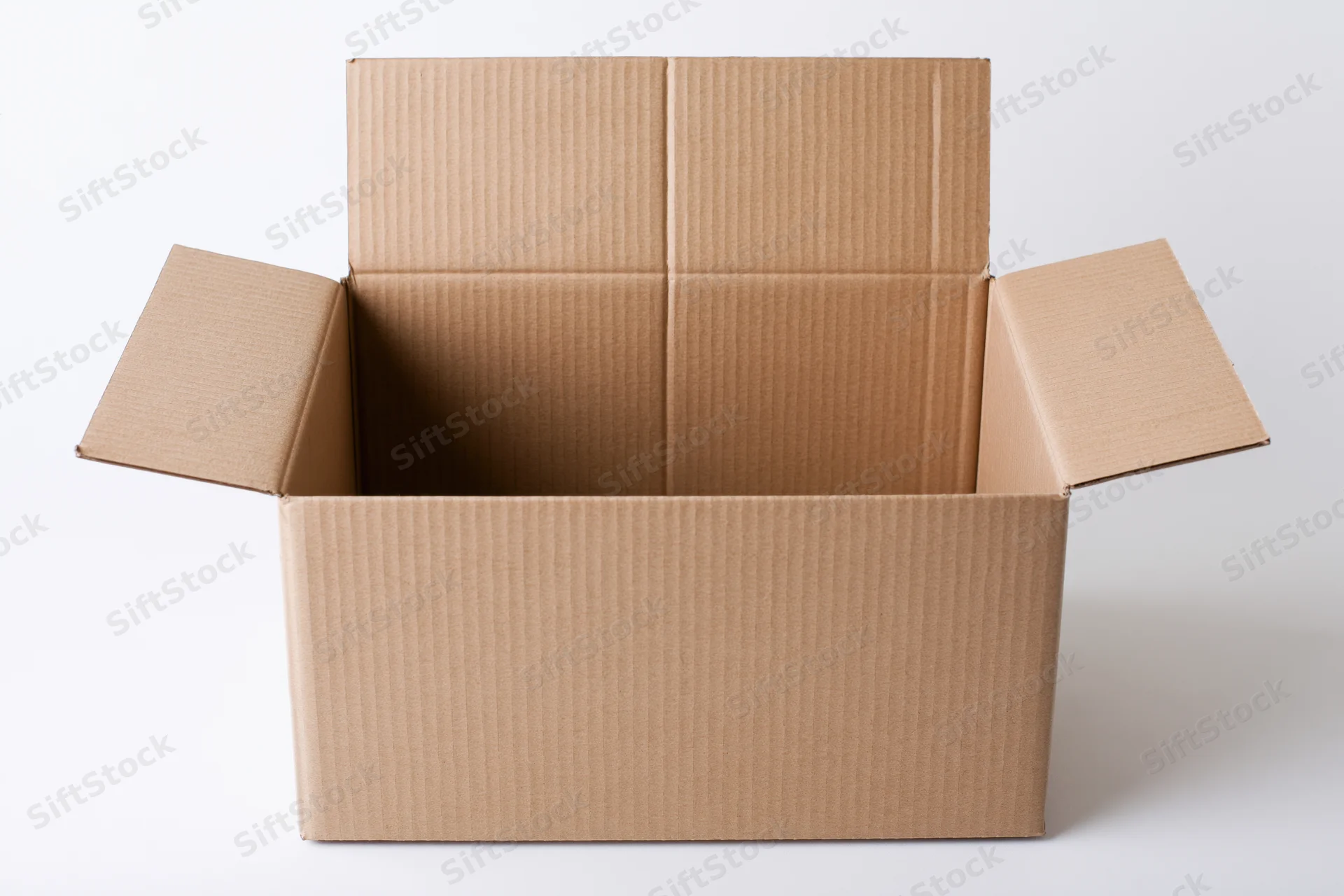 Open empty corrugated cardboard shipping box with flaps folded back on white background