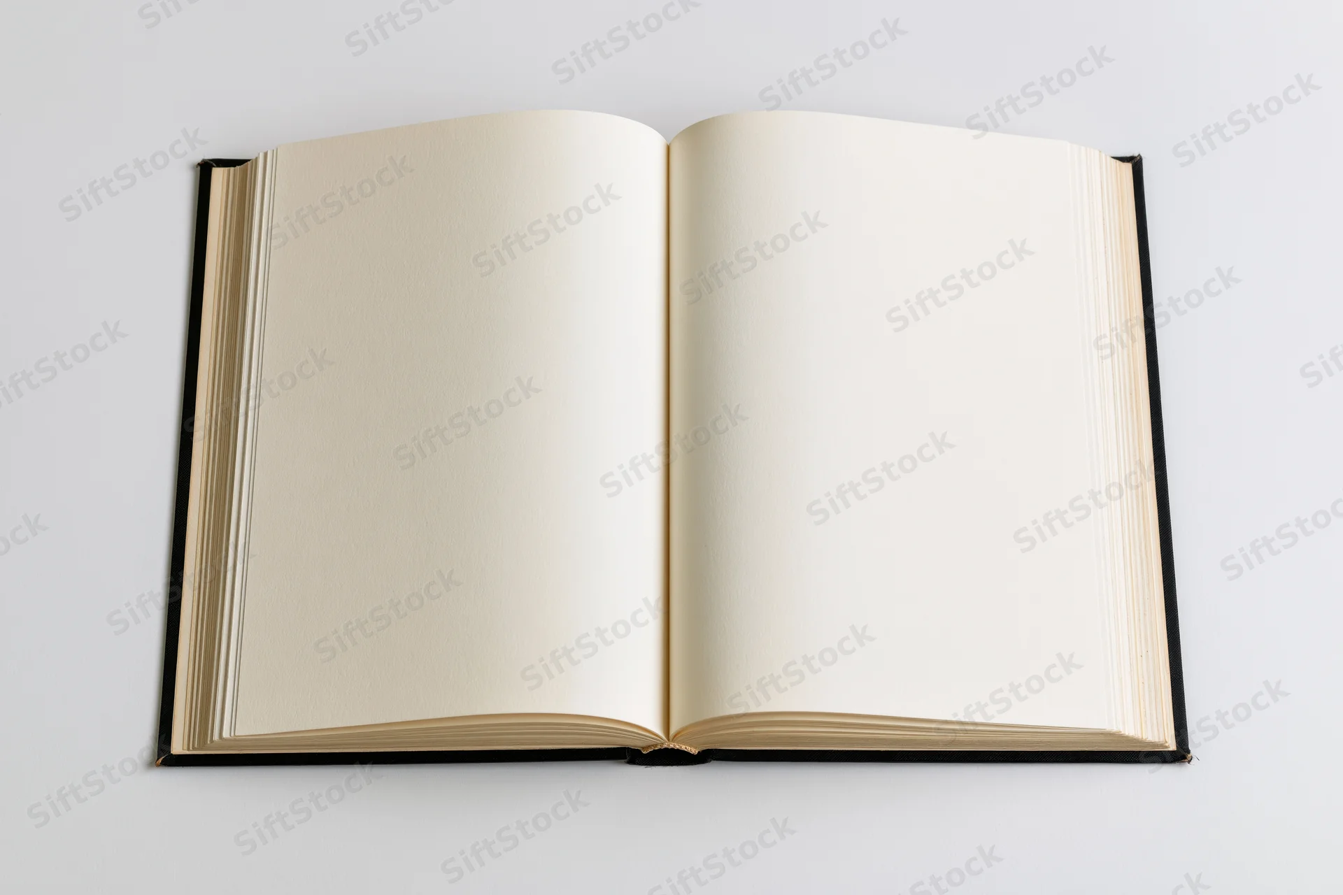 Open hardcover book with blank cream pages lying flat spread on white background