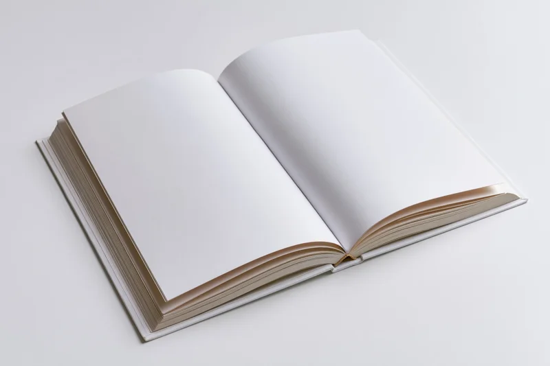 Open hardcover book with blank white pages spread flat on white background