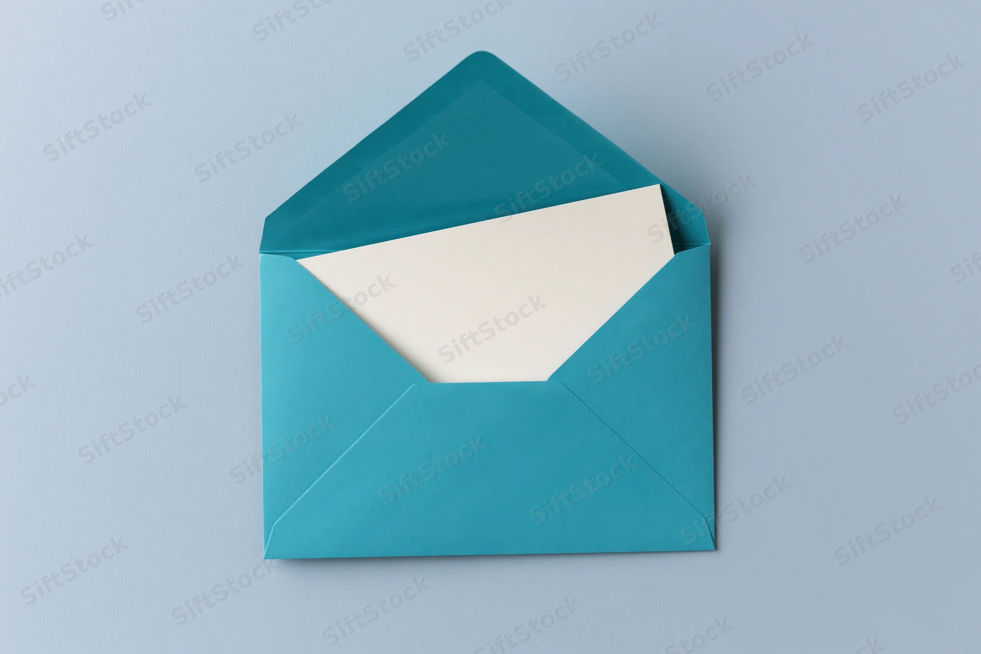 Open teal envelope with blank white card inside on light blue surface