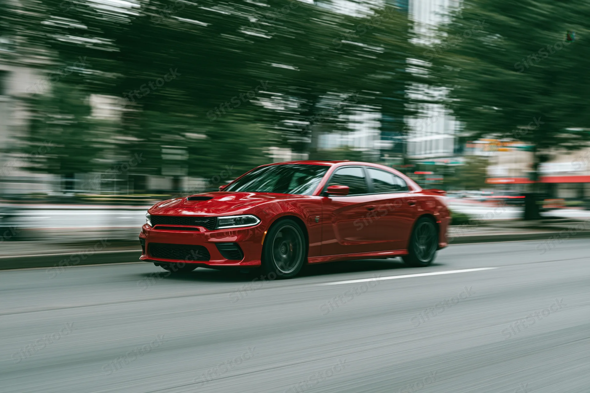 Red performance sedan driving fast on urban street with motion blur