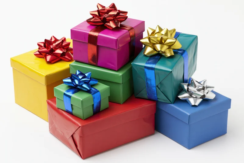 Colorful wrapped gift boxes stacked in a loose pile on white background