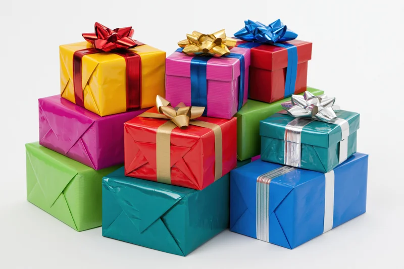 Colorful wrapped gift boxes stacked in a loose pile on white background
