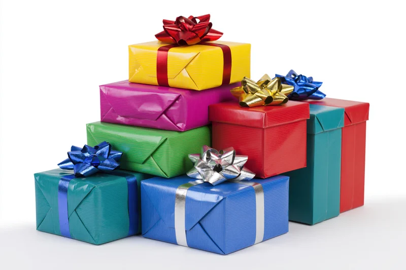 Colorful wrapped gift boxes stacked in a loose pile on white background