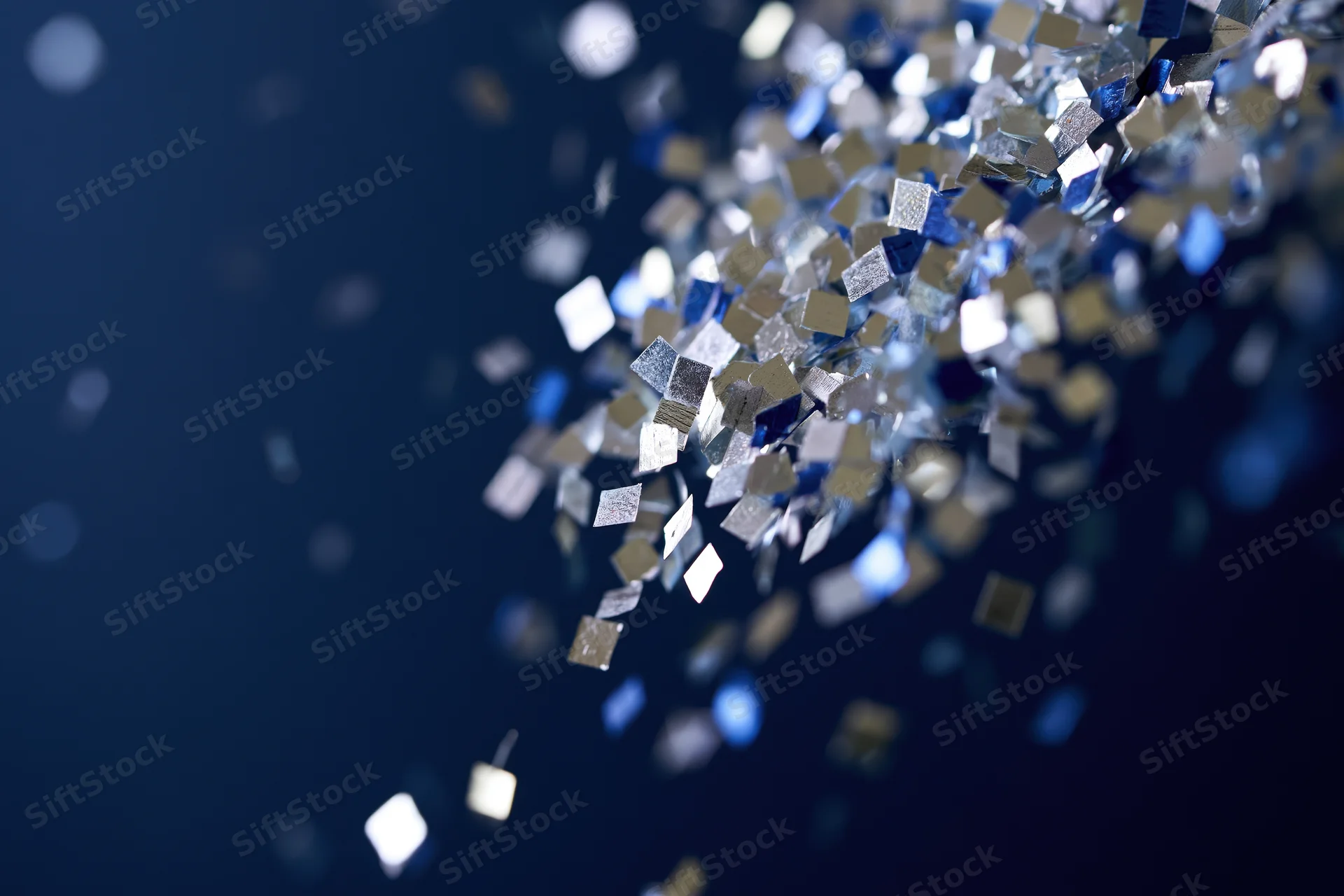 Metallic square confetti floating in mid-air against a dark blue background