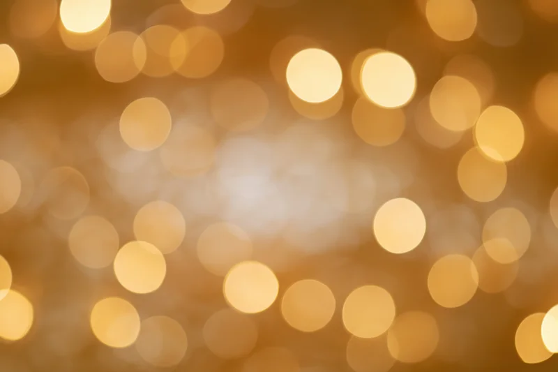 Soft golden bokeh lights in circular blur as festive background