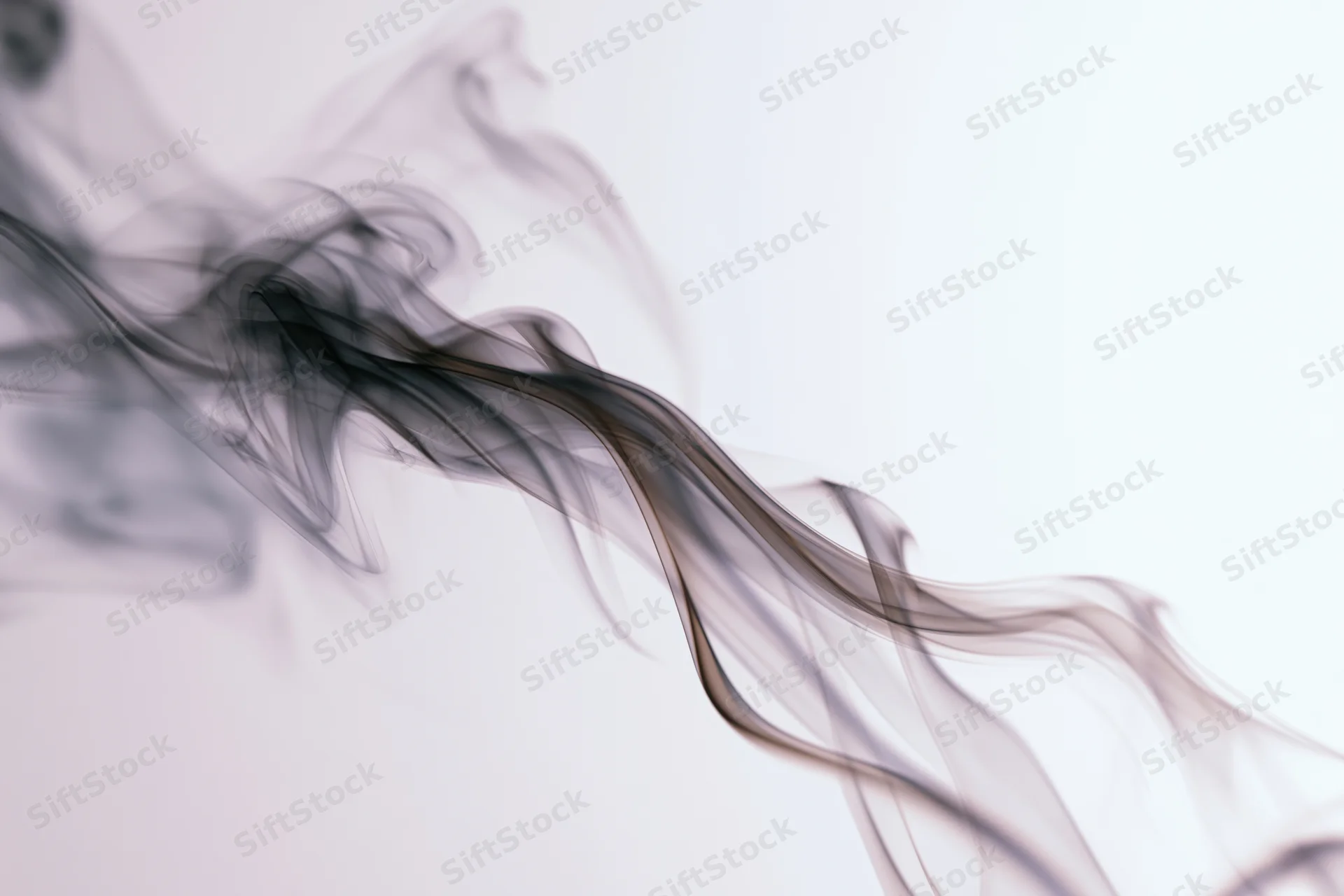 Dark smoke wisps curling upward against a white background