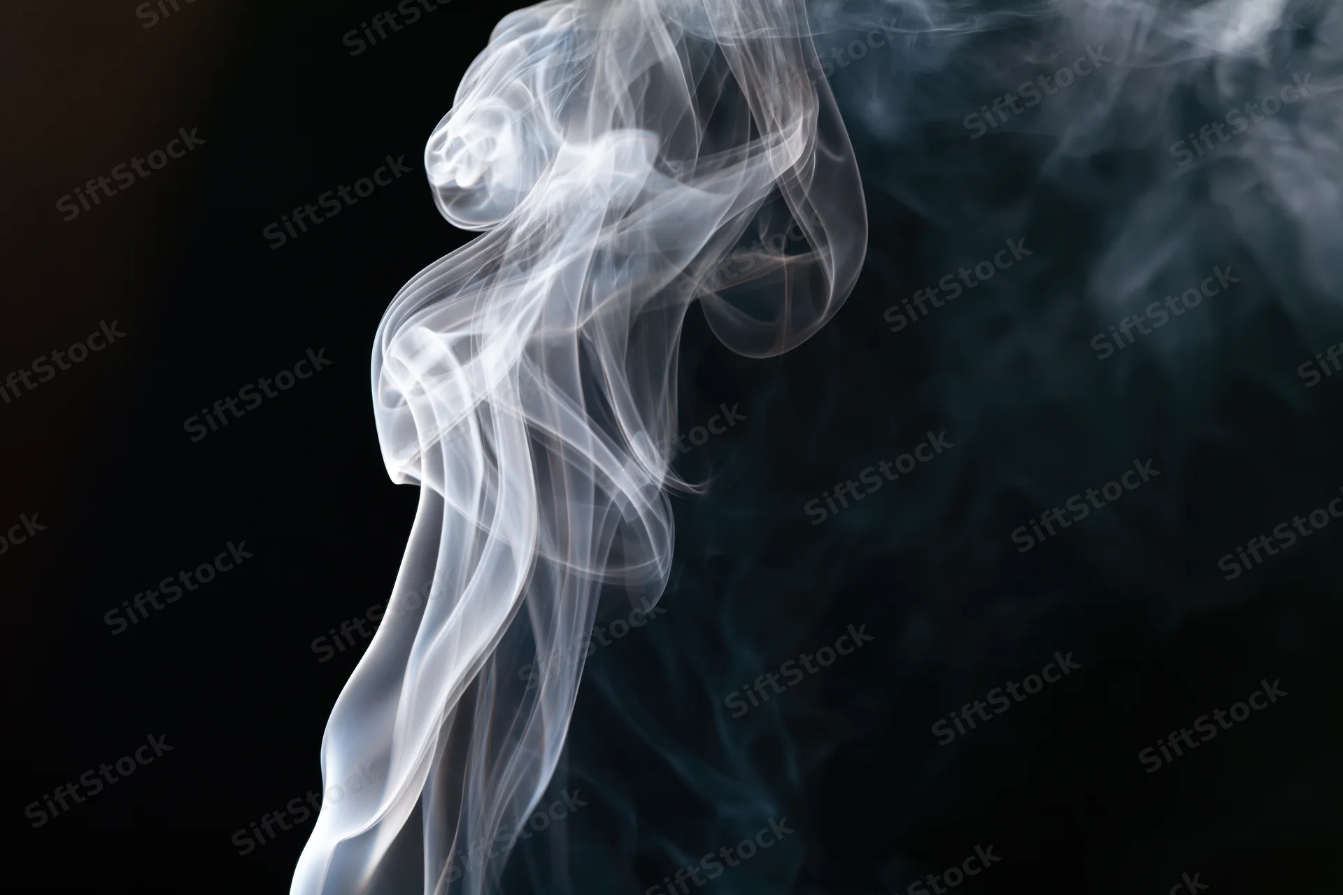 White smoke curling upward against a dark background