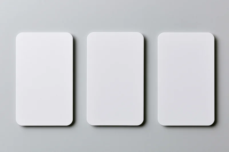 Three blank white cards with rounded corners arranged side by side on a gray surface
