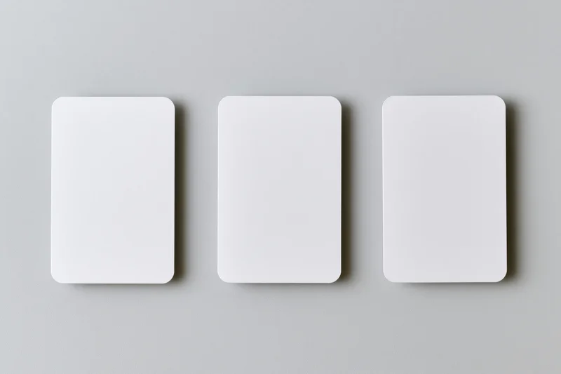 Three blank white cards with rounded corners arranged horizontally on a gray surface