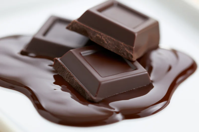 Three chocolate squares sitting in a pool of melted chocolate