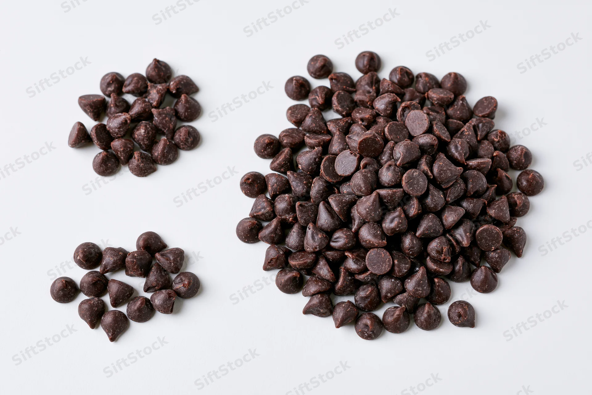 Chocolate Chips on White Surface: Glossy, Dark Bitesized Pieces
