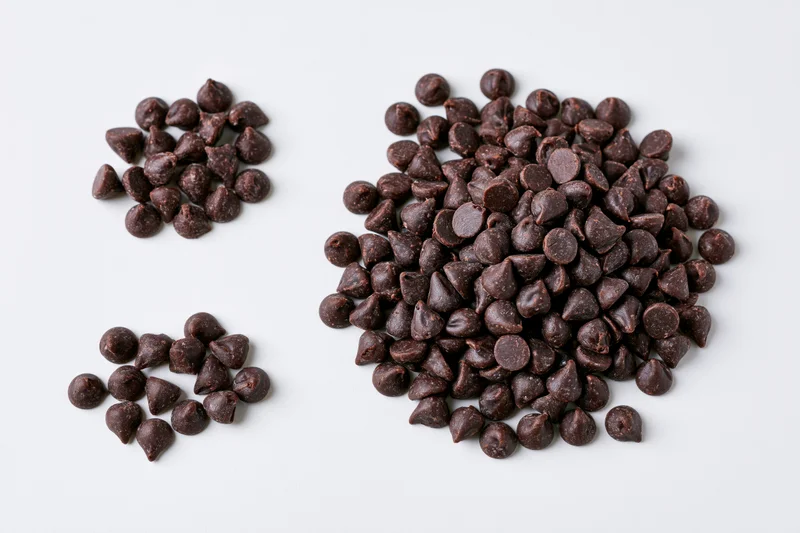 Chocolate Chips on White Surface: Glossy, Dark Bitesized Pieces