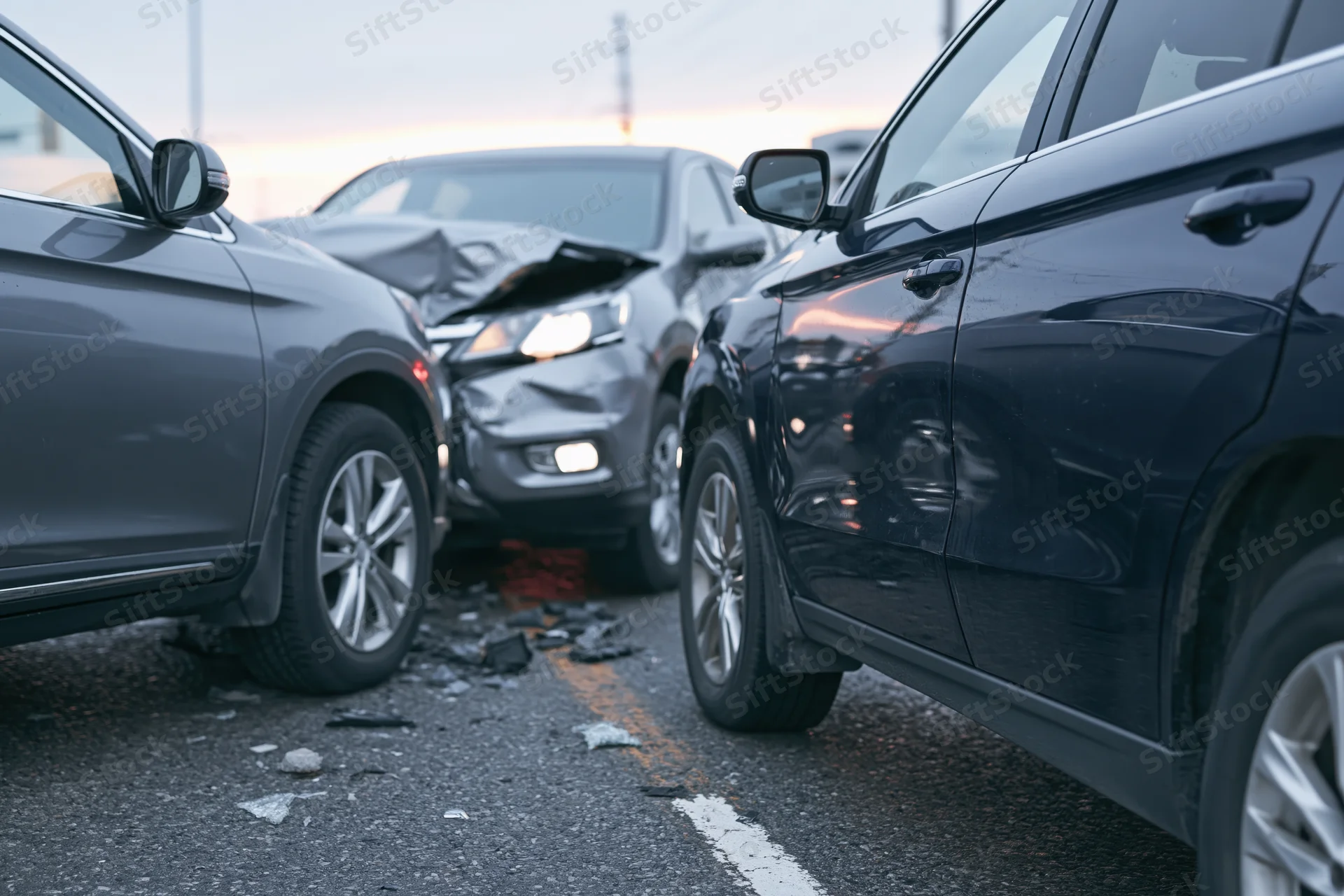 Two suvs involved in a front-end collision on an urban road with visible damage and debris on the asphalt