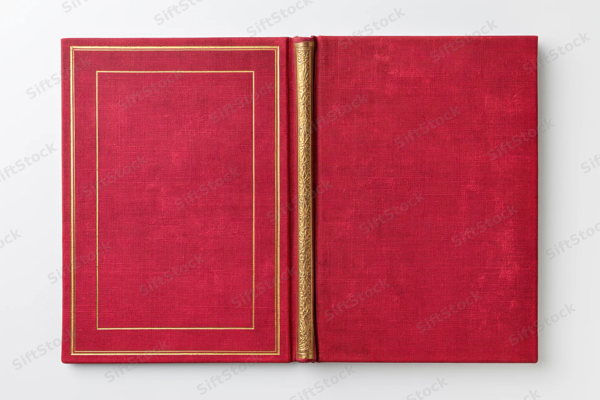 Open vintage hardcover book with red cloth covers and gold embossed frame lying flat on white background