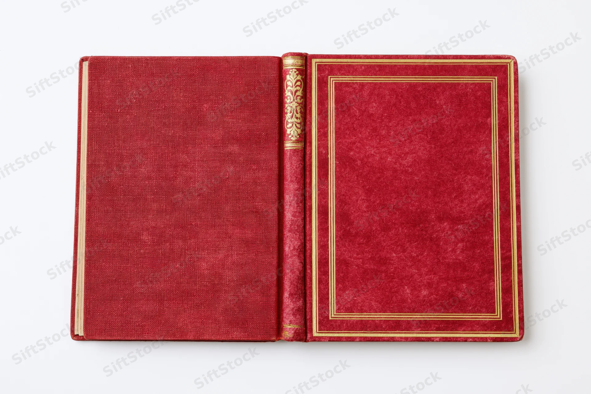 Open vintage hardcover book with red textured covers and gold embossed spine lying flat on white background