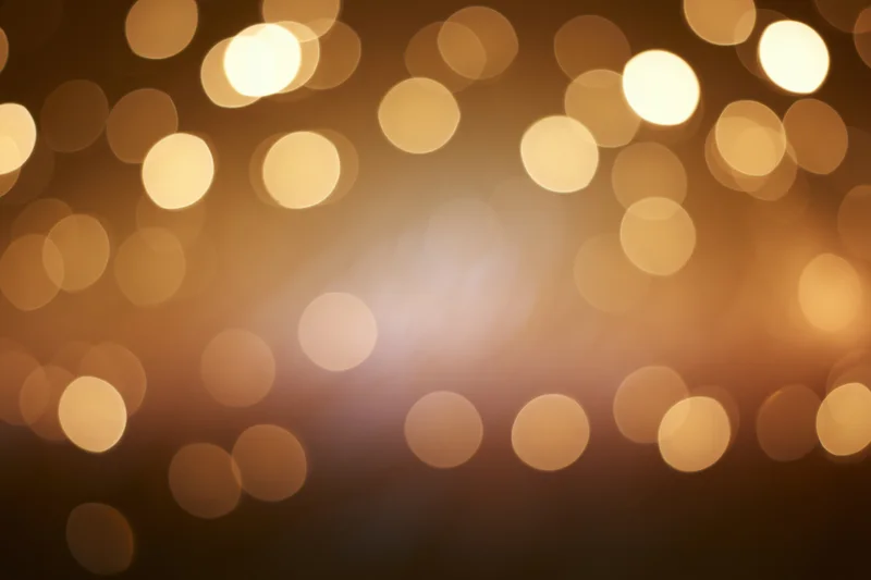 Warm golden bokeh lights scattered across a soft blurred background with copyspace
