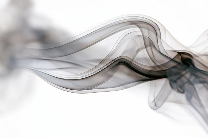 Wispy black smoke tendrils swirling across a pure white background