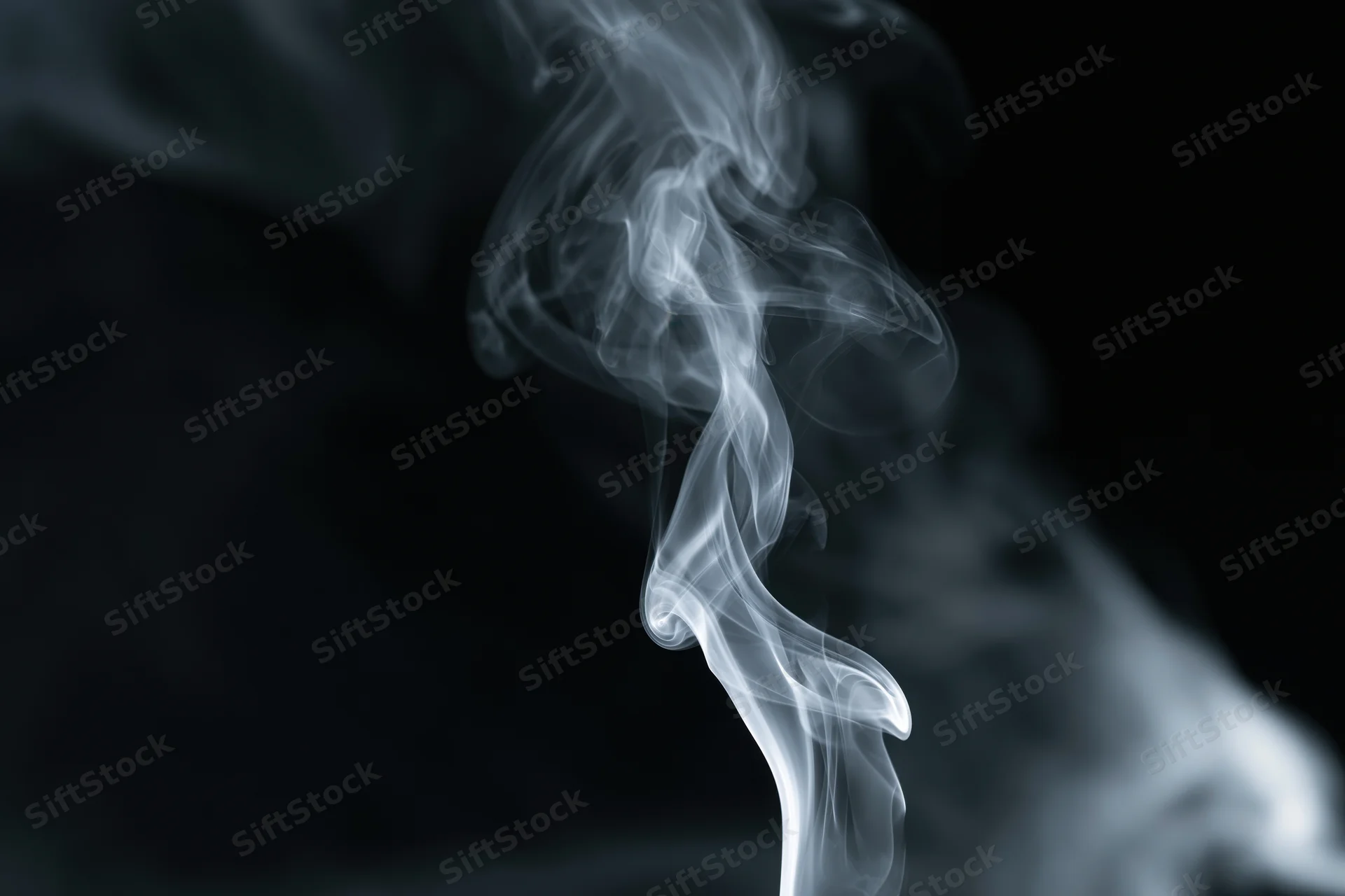 White smoke curling upward against a black background