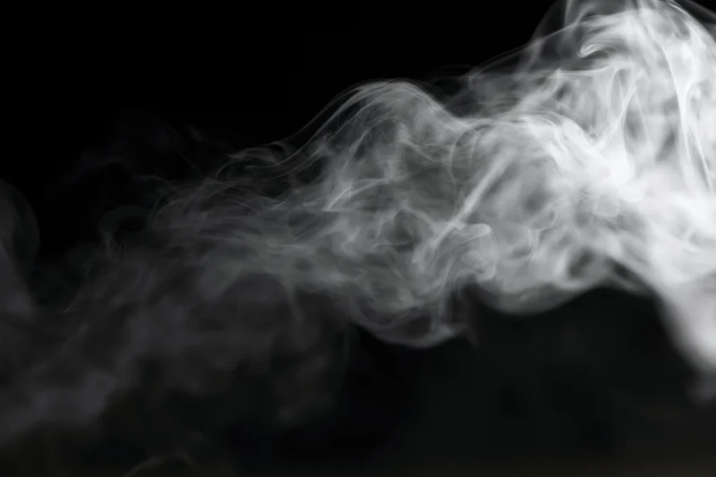 White smoke swirling upward against a black background