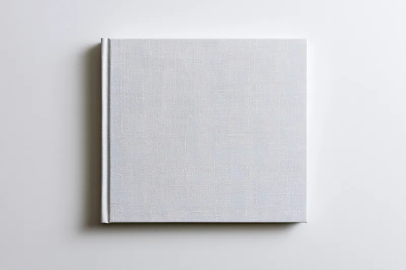 Blank square hardcover book lying flat on white surface