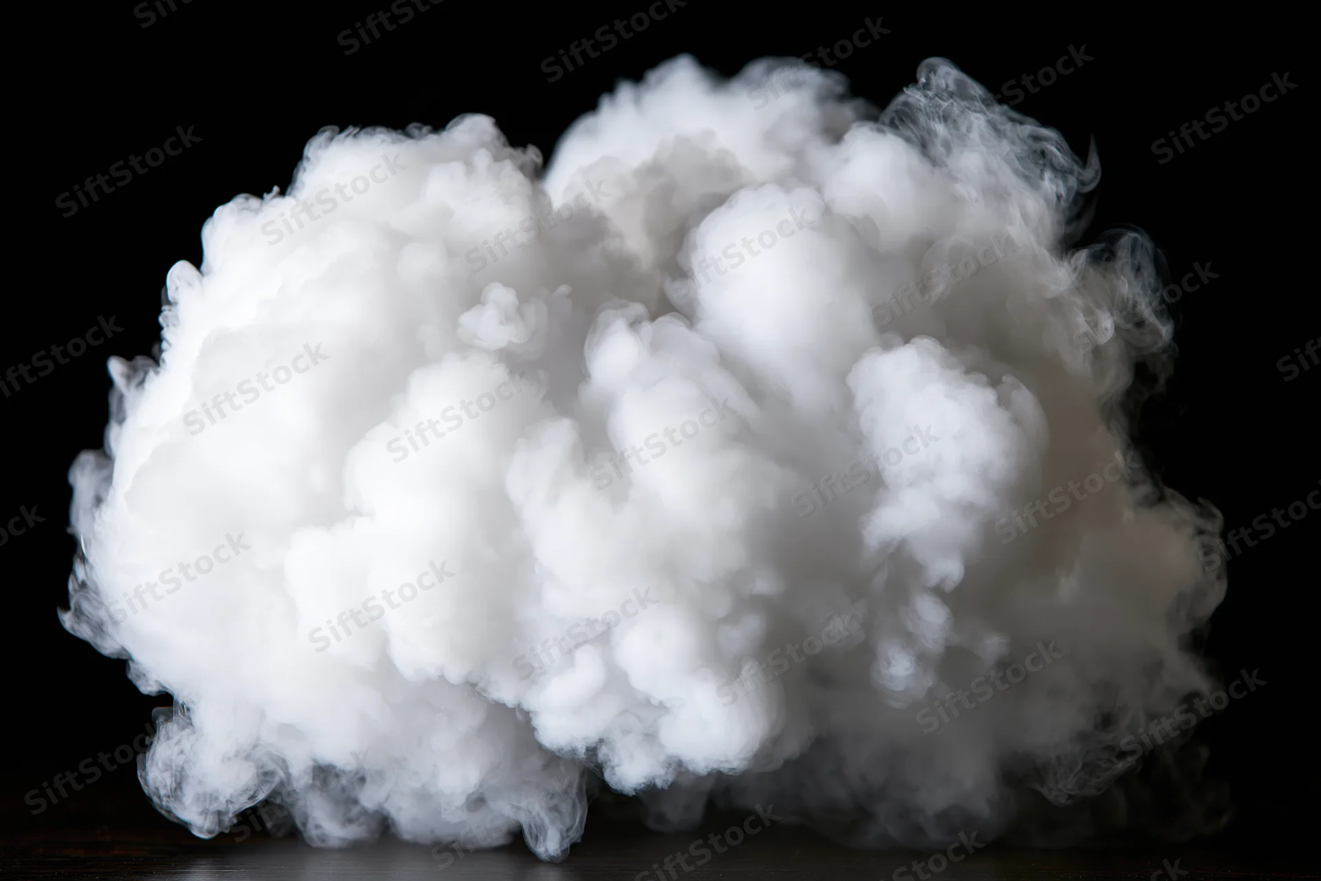 Dense white smoke cloud billowing mid-air against black background