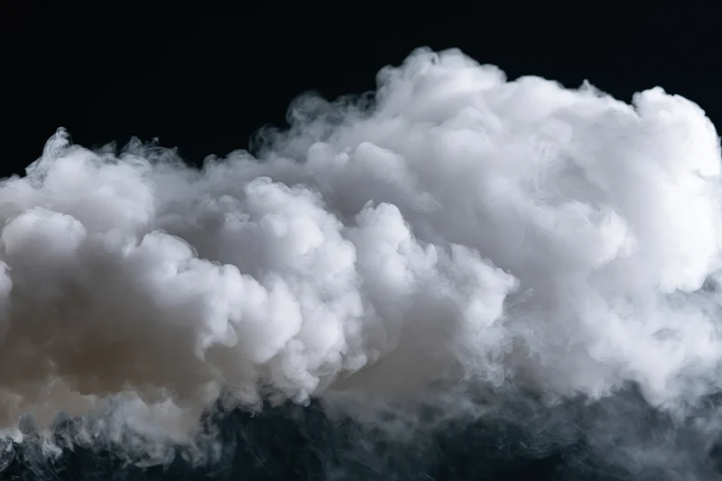 Dense white smoke billowing horizontally against black background