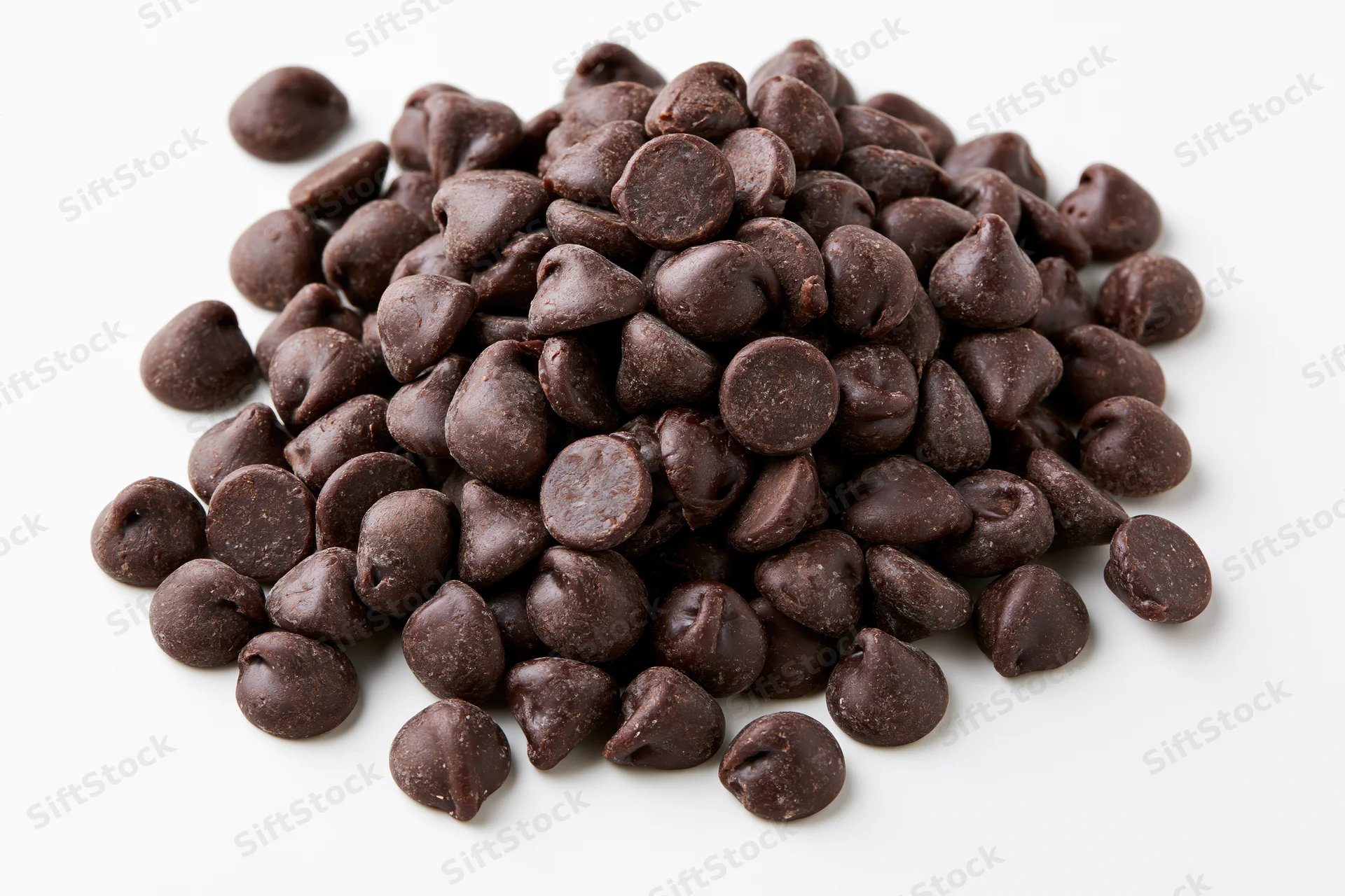 Pile of dark chocolate chips on white background