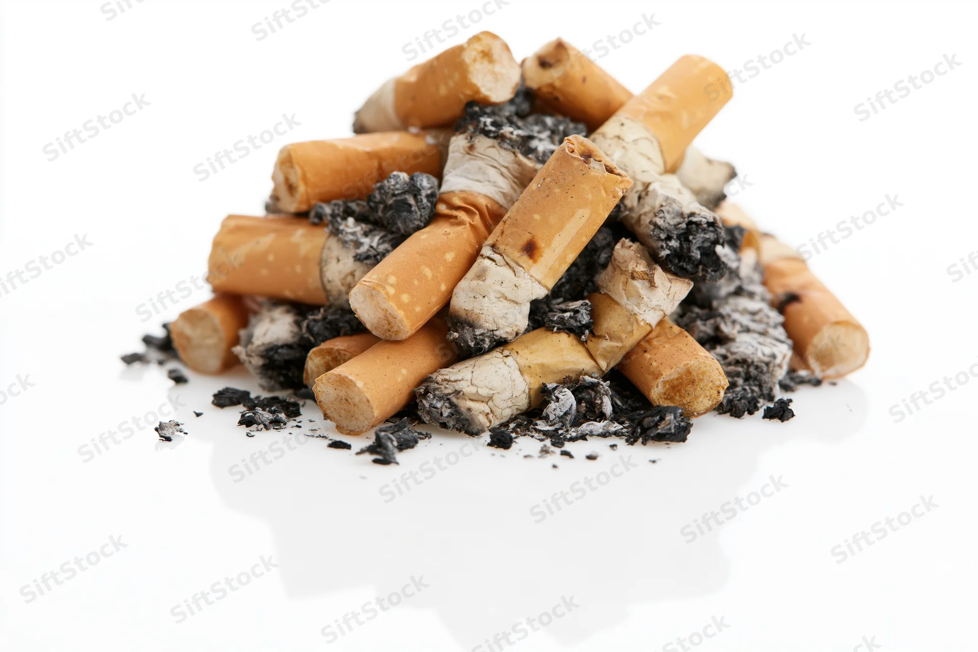 Pile of used cigarette butts with ash scattered on white background