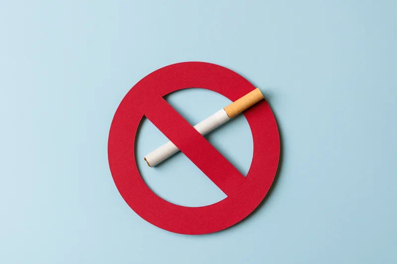 Red no-smoking symbol with cigarette on blue background