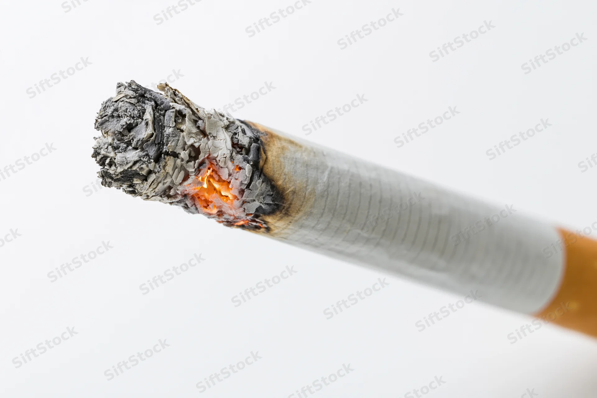 Lit cigarette angled diagonally with burning tip and ash against white background