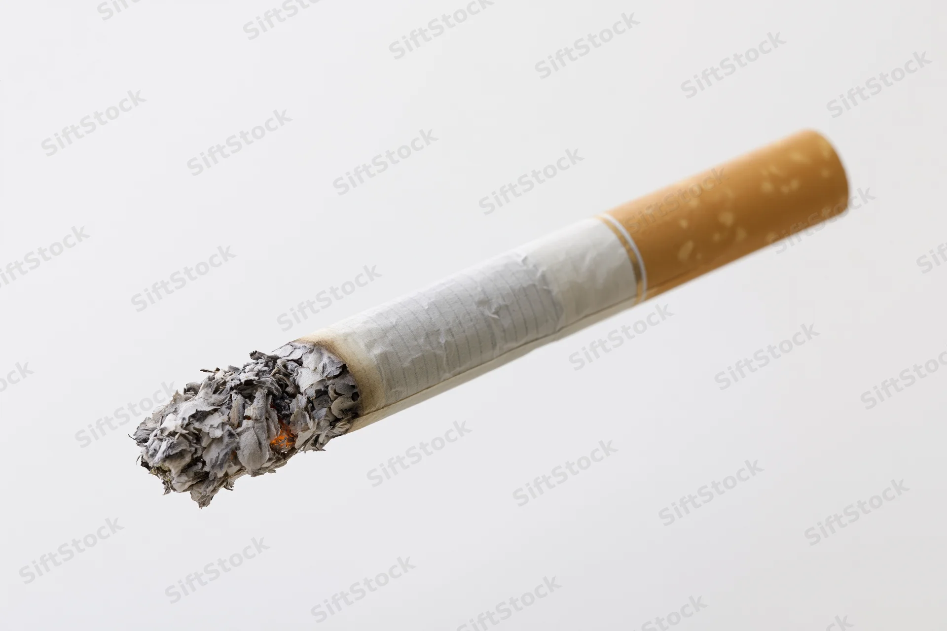 Lit cigarette with glowing ember and crumbling ash on white background