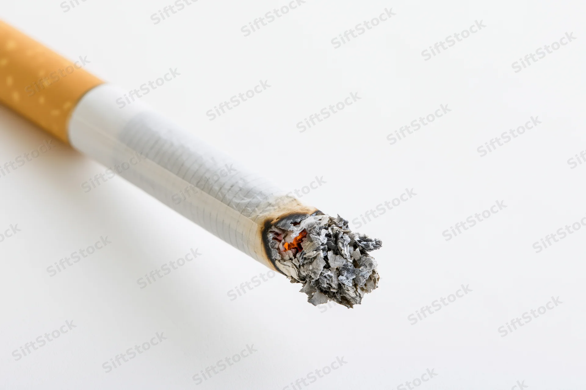 Lit cigarette with glowing ember and ash on white background
