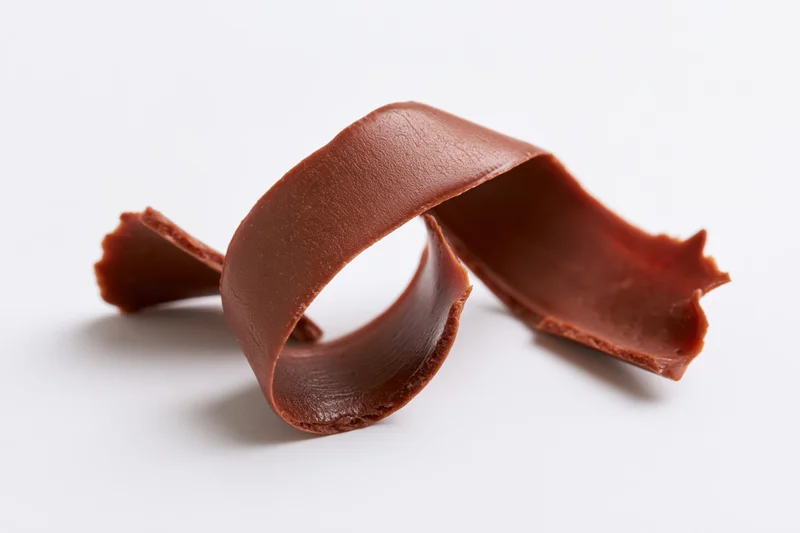 Milk chocolate curl shaving on white background