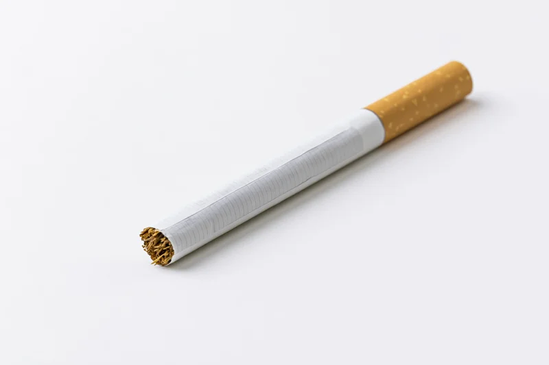 Unlit cigarette lying diagonally with white paper body filter