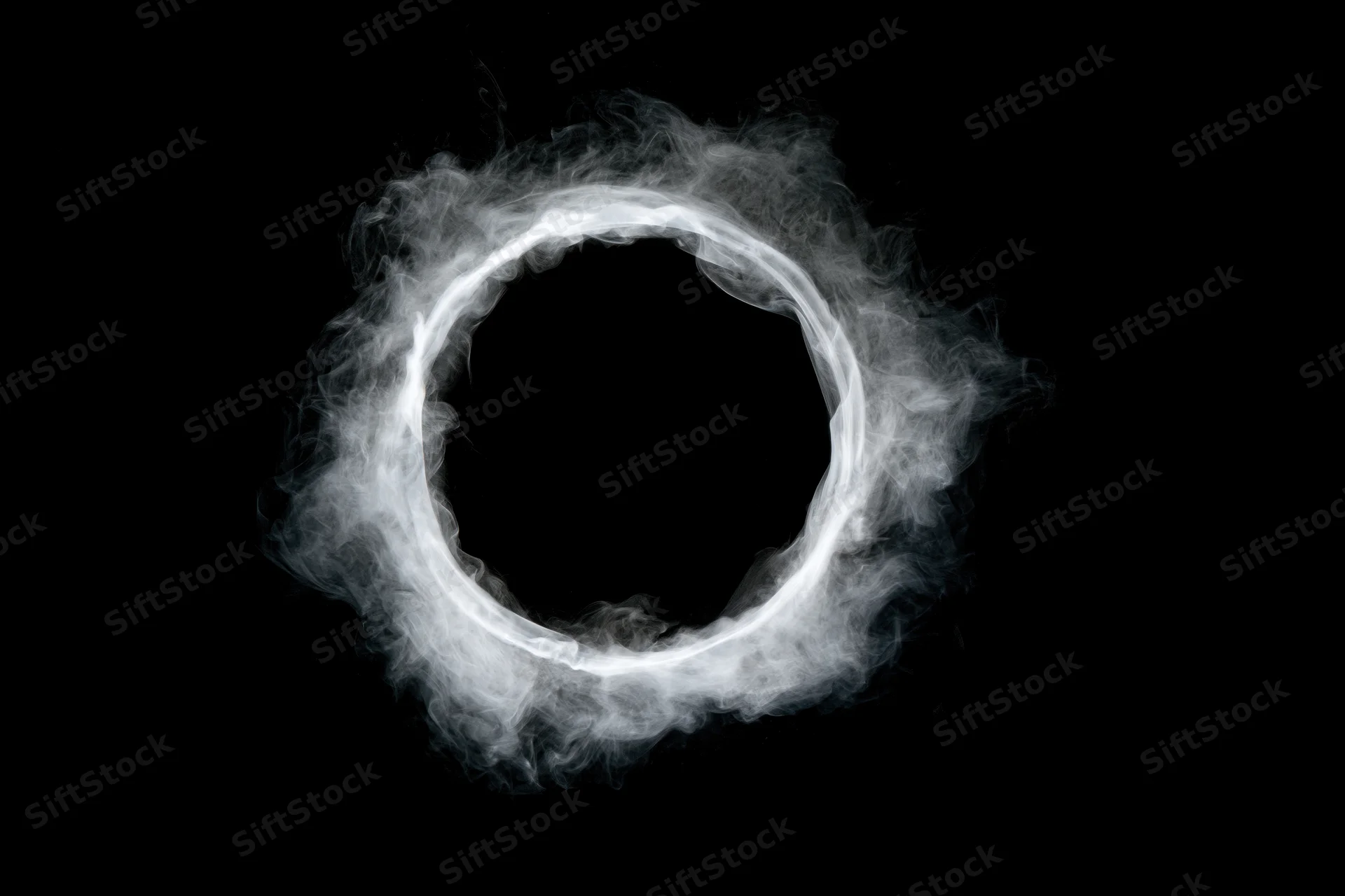 White smoke ring floating in midair against black background
