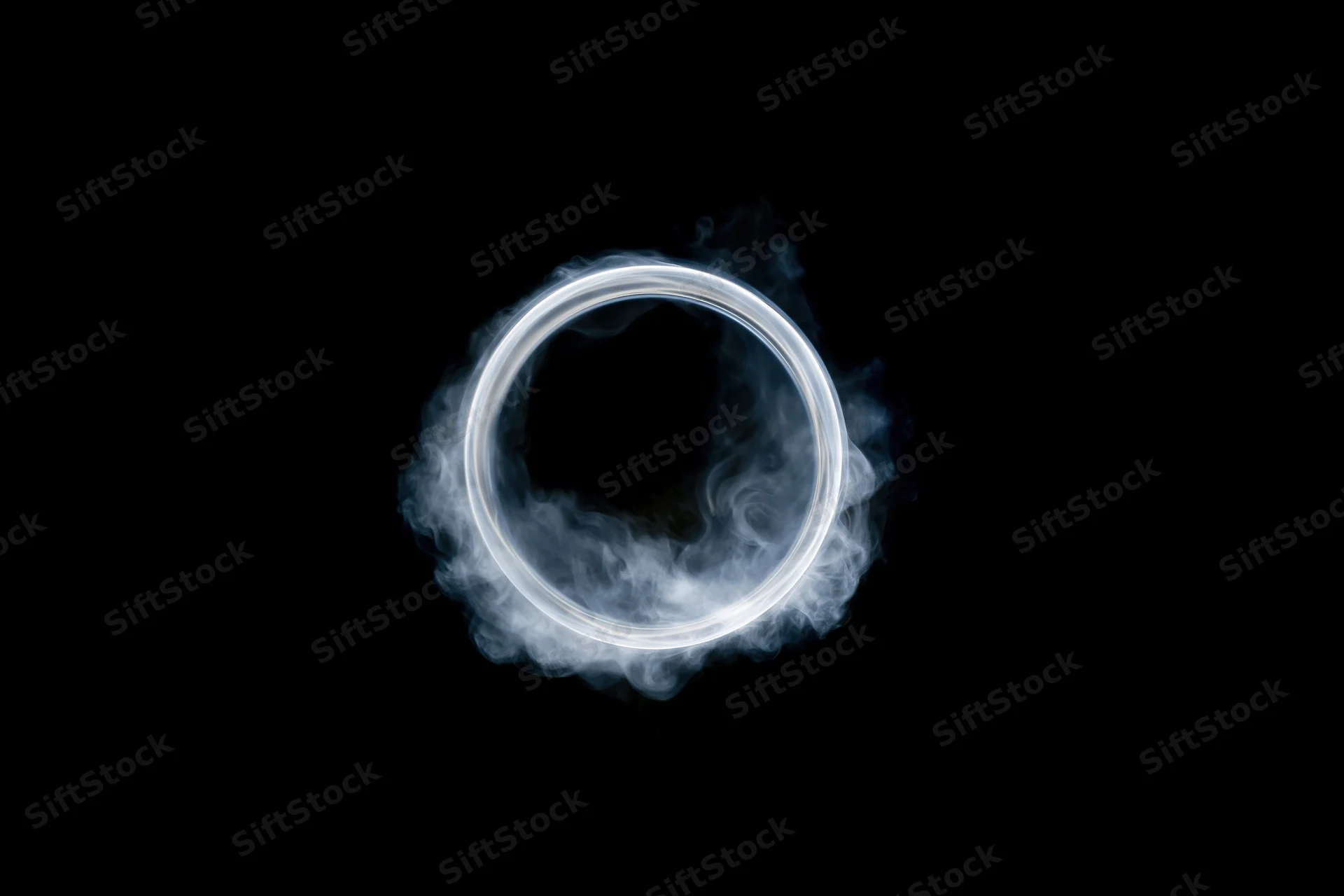 White smoke ring floating midair against black background