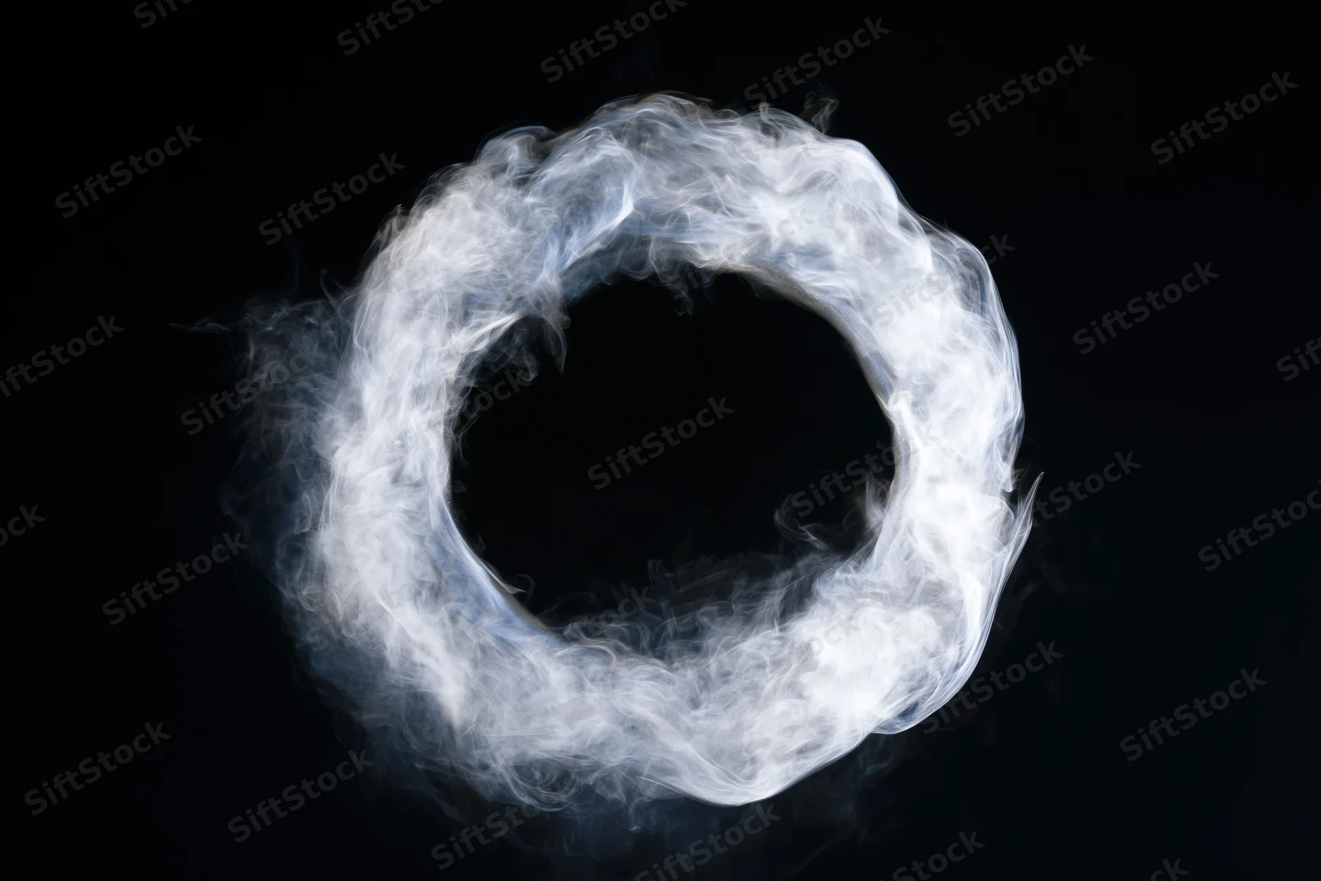 White smoke ring floating midair against black background