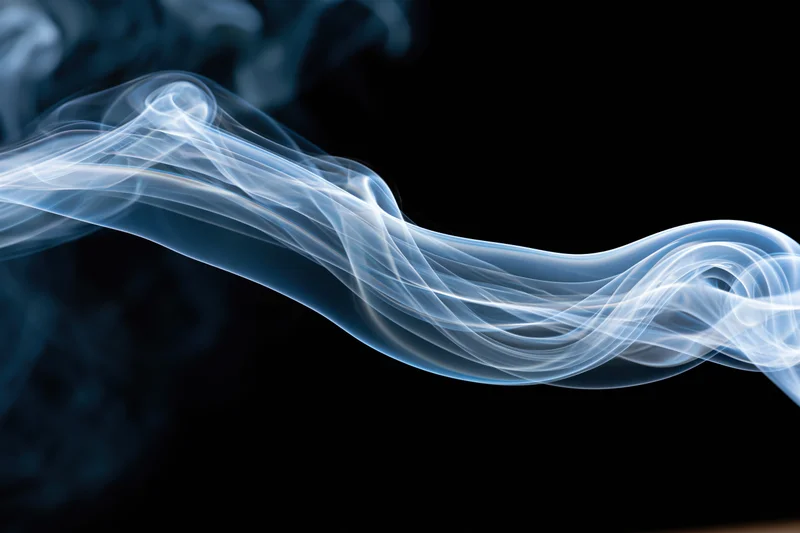A single wisp of smoke curling and twisting horizontally across a black background