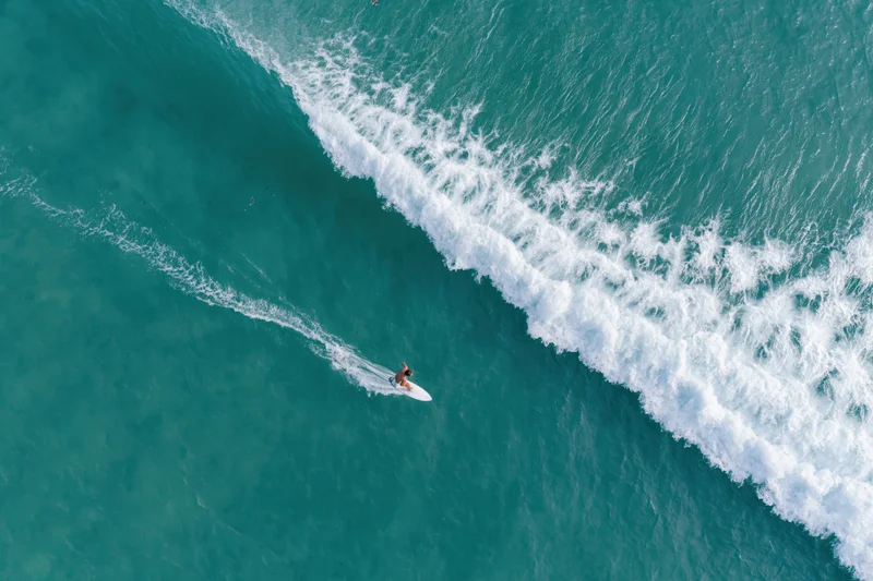Surfer riding a wave from an aerial overhead view