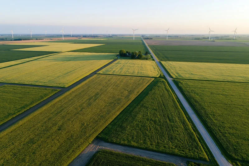 Aerial view of cultivated fields and wind turbines in midwestern farmland