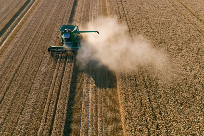 Aerial drone view looking straight down at green combine harvester