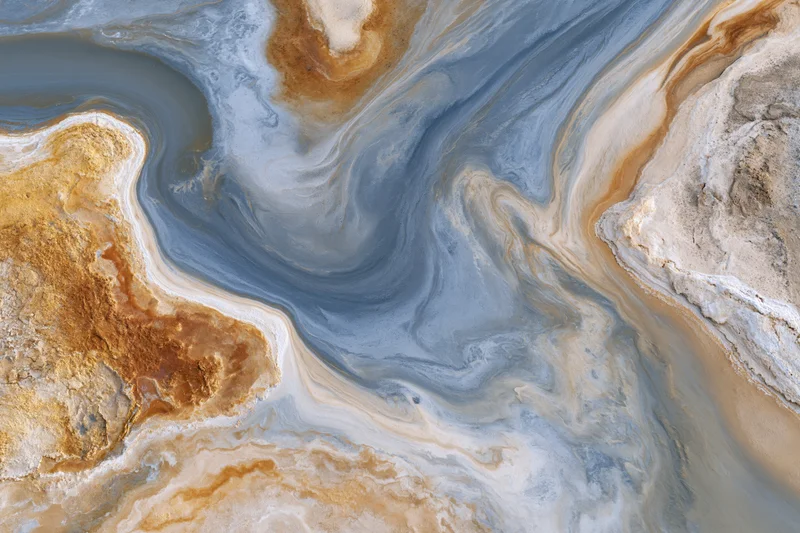 Aerial top-down view of a salt lake tidal flat landscape with swirling mineral patterns and dry earth textures