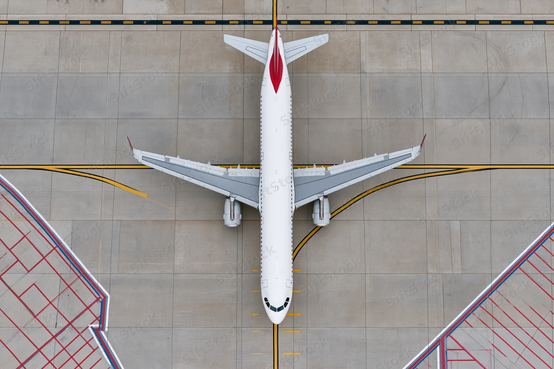 White commercial passenger jet viewed from above on airport tarmac