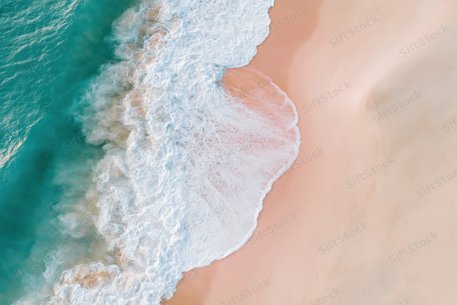 Aerial top-down view of ocean waves breaking on a sandy beach