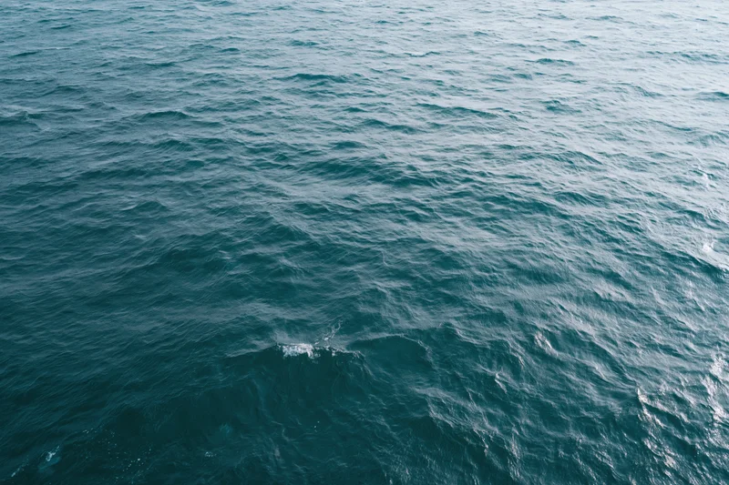 Aerial top-down view of open ocean surface with small wind-driven waves