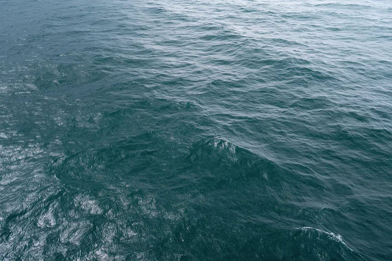 Aerial top-down view of open ocean surface with small wind-driven waves and ripples