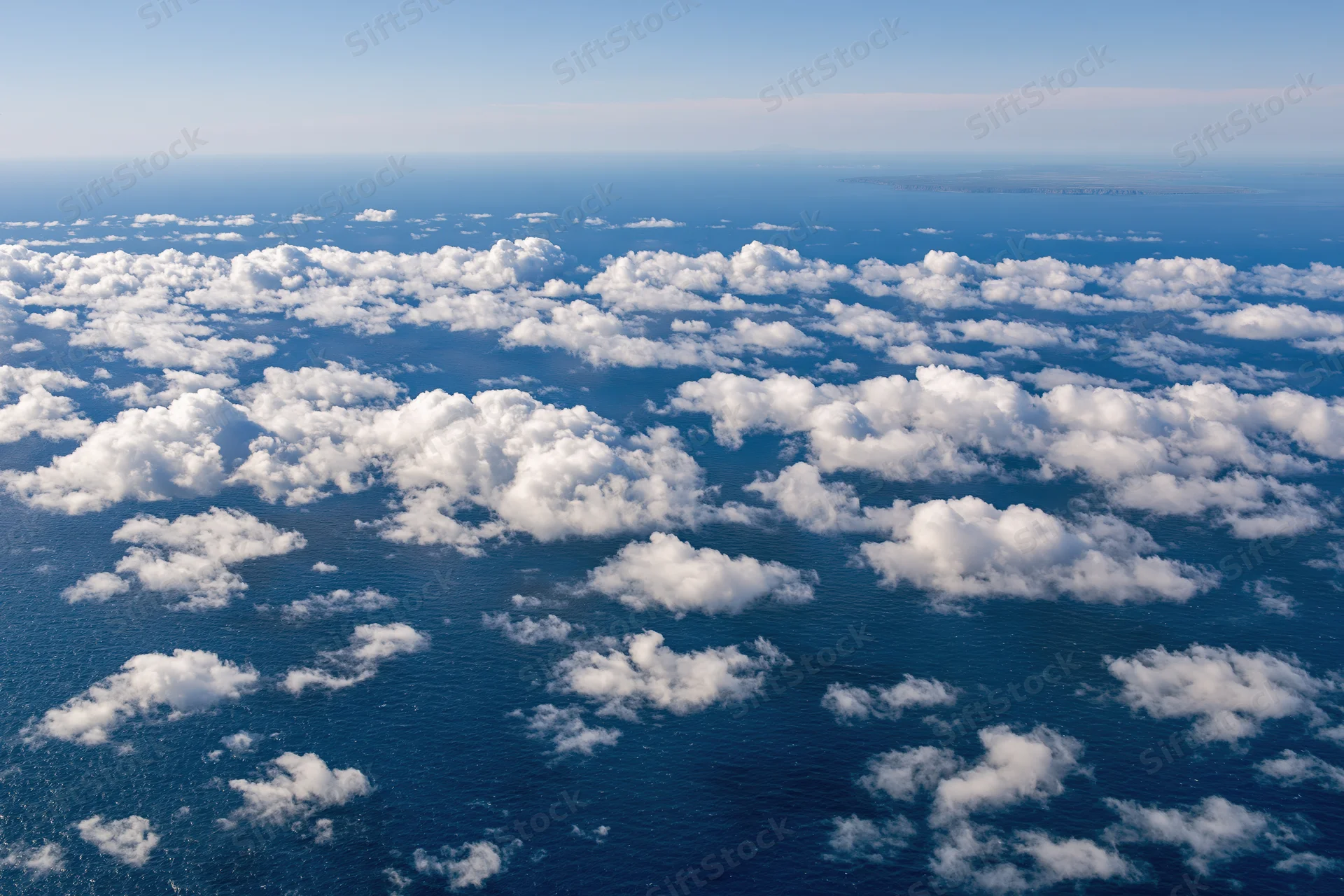 Aerial view of white clouds over deep blue ocean from above