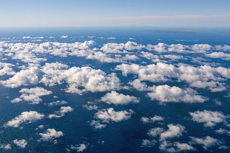 Aerial view of white clouds over deep blue ocean from above