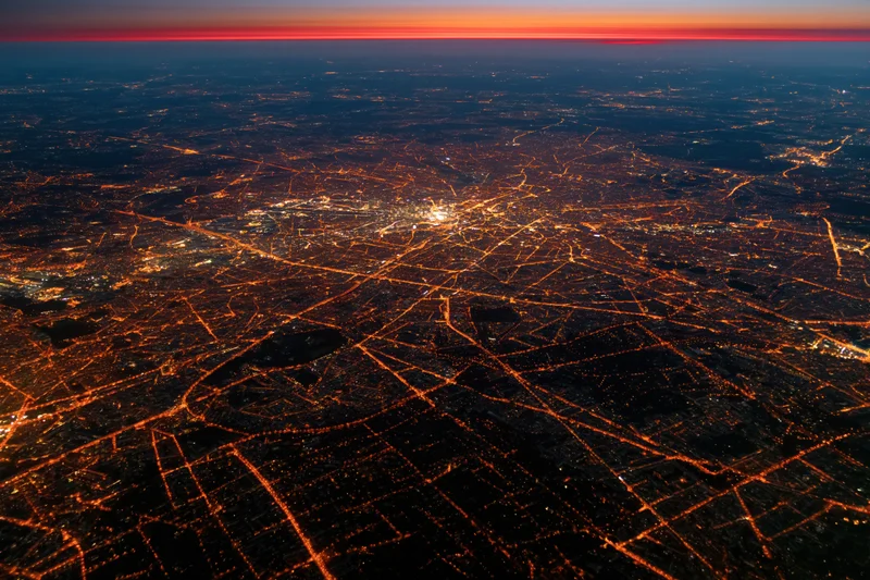 Aerial view of a european city at night showing illuminated streets and urban grid from above